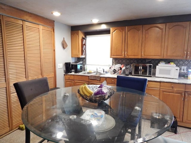13 Lark St, New Bedford, MA 02745 - kitchen with brown cabinets, tasteful backsplash, a sink, and white microwave