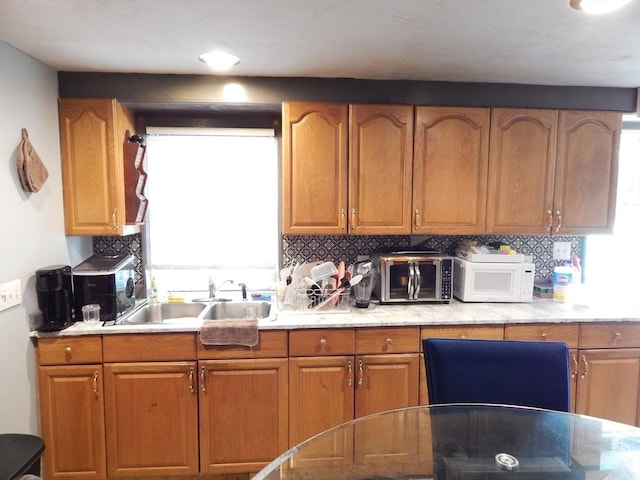 13 Lark St, New Bedford, MA 02745 - kitchen with backsplash, brown cabinetry, and white microwave