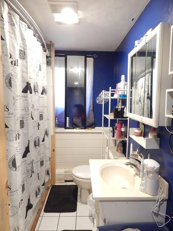 13 Lark St, New Bedford, MA 02745 - bathroom with toilet, tile patterned floors, vanity, and curtained shower