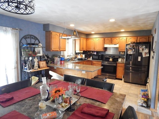 13 Lark St, New Bedford, MA 02745 - kitchen with a peninsula, light tile patterned floors, a sink, black appliances, and under cabinet range hood