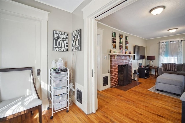 living room featuring a fireplace, hardwood / wood-style flooring, and ornamental molding