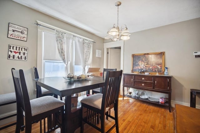 dining area featuring light hardwood / wood-style floors and a chandelier