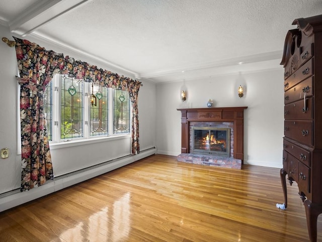 47 Skelton Rd, Burlington, MA 01803 - unfurnished living room with baseboard heating, wood finished floors, a glass covered fireplace, a textured ceiling, and beam ceiling