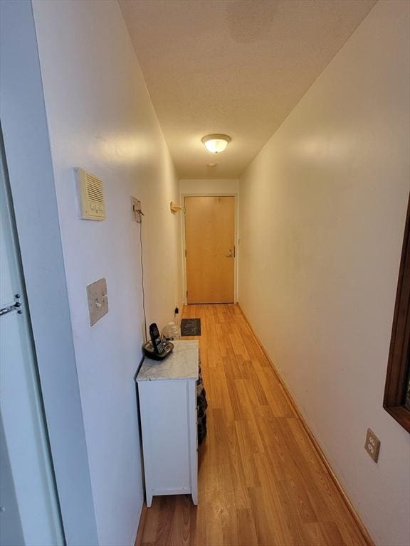 corridor with light hardwood / wood-style floors