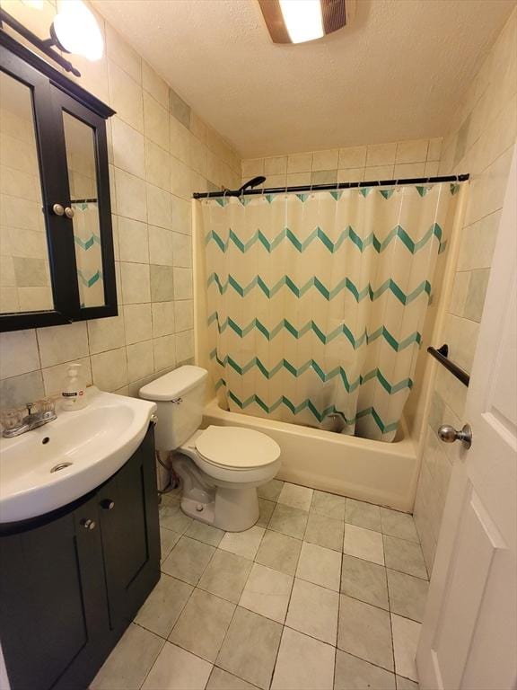 full bathroom with a textured ceiling, shower / tub combo with curtain, tile walls, toilet, and vanity