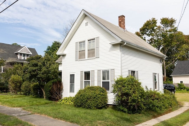 view of side of home with a lawn