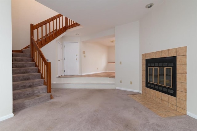 118 Tall Oaks Dr Unit D, Weymouth, MA 02190 - unfurnished living room featuring carpet floors, stairway, baseboards, and a tile fireplace