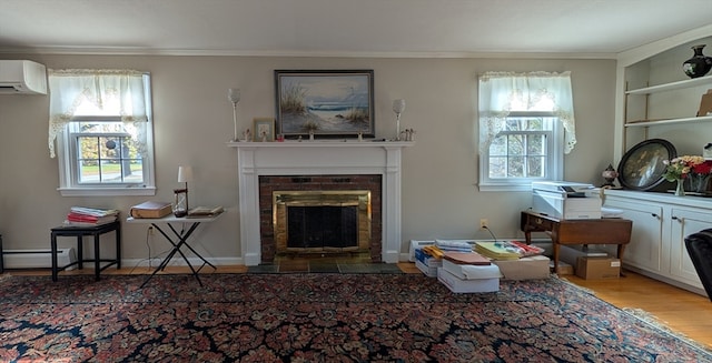 sitting room featuring a wall mounted air conditioner, baseboard heating, crown molding, a fireplace, and hardwood / wood-style floors