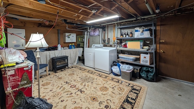 basement featuring a wood stove and washing machine and clothes dryer