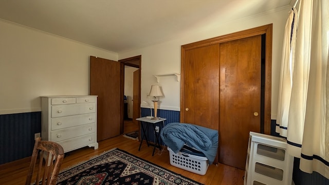 bedroom with ornamental molding, light hardwood / wood-style flooring, and a closet