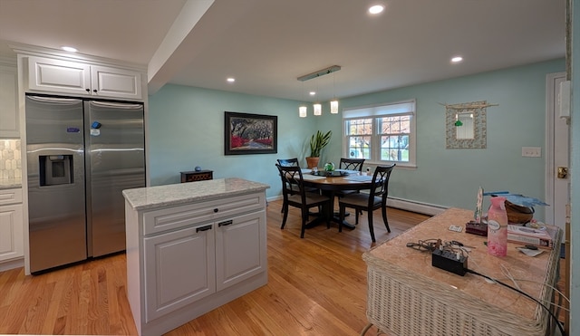 kitchen featuring white cabinets, stainless steel fridge, light hardwood / wood-style floors, and a kitchen island