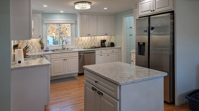 kitchen featuring appliances with stainless steel finishes, light hardwood / wood-style flooring, and white cabinetry