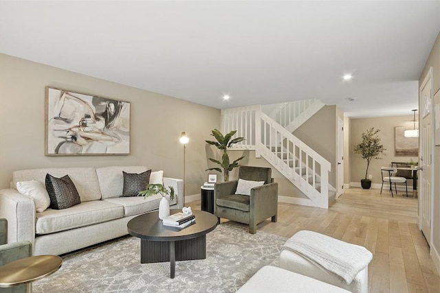 living area with recessed lighting, stairway, baseboards, and light wood-style floors