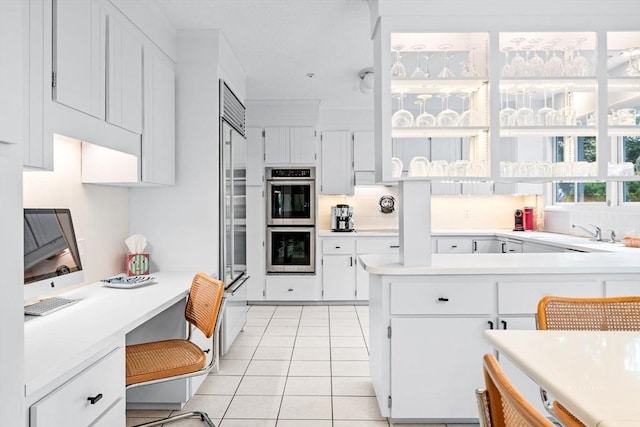 228 Atlantic Ave, Swampscott, MA 01907 - kitchen featuring double oven, light countertops, tasteful backsplash, a sink, and white cabinets