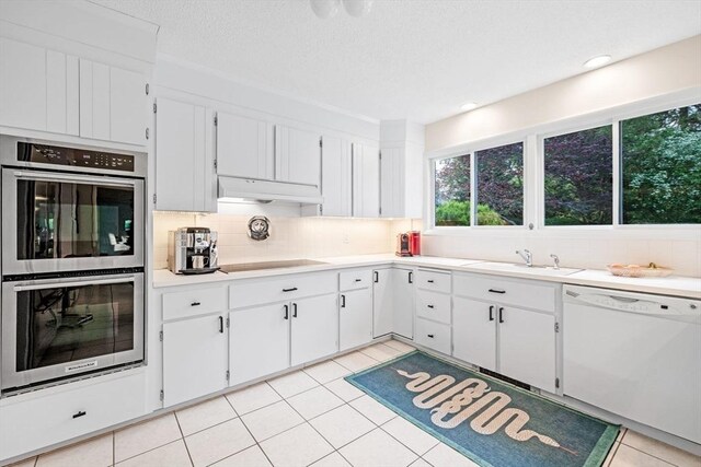 228 Atlantic Ave, Swampscott, MA 01907 - kitchen featuring stainless steel double oven, white dishwasher, a sink, tasteful backsplash, and black electric stovetop