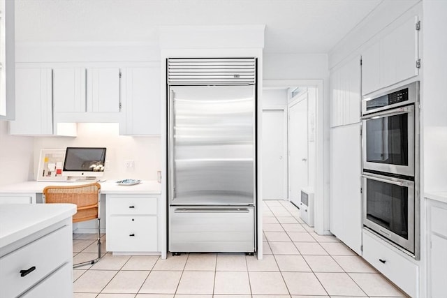 228 Atlantic Ave, Swampscott, MA 01907 - kitchen featuring appliances with stainless steel finishes, light tile patterned flooring, light countertops, and white cabinetry