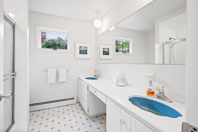 228 Atlantic Ave, Swampscott, MA 01907 - bathroom with baseboard heating, a stall shower, double vanity, tile patterned floors, and tile walls