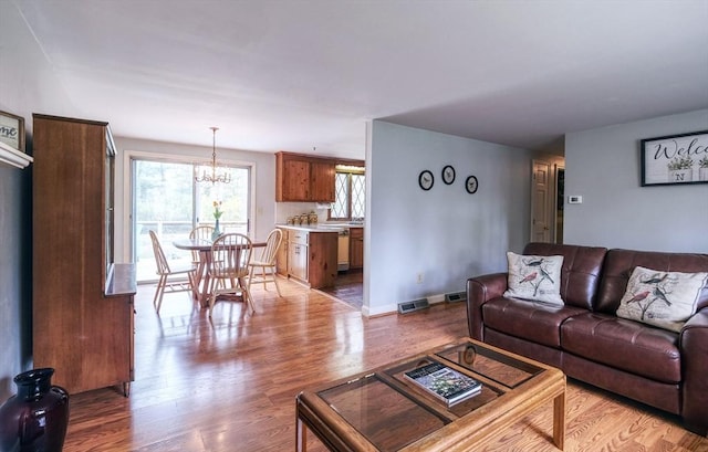 living room featuring a chandelier and light wood-type flooring