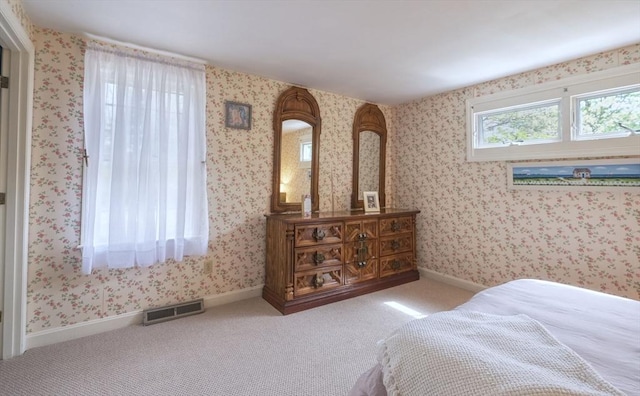 carpeted bedroom with wallpapered walls and baseboards