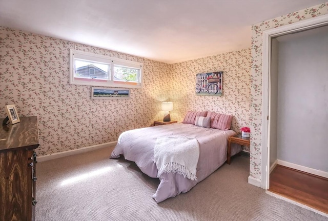carpeted bedroom with baseboards and wallpapered walls