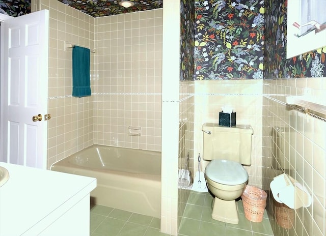 full bathroom with tile walls, tile patterned flooring, toilet, vanity, and shower / bathtub combination