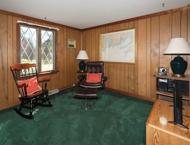 sitting room with carpet, baseboards, and wood walls
