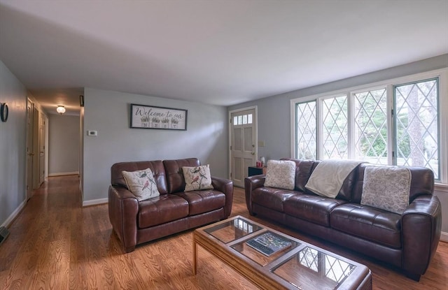 living area featuring plenty of natural light, wood finished floors, and baseboards