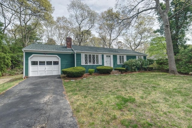 ranch-style home with a garage, a chimney, driveway, a front lawn, and a shingled roof