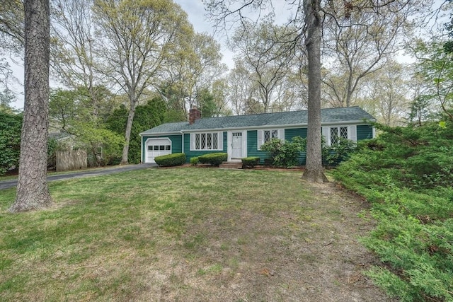 ranch-style house with a garage, asphalt driveway, and a chimney