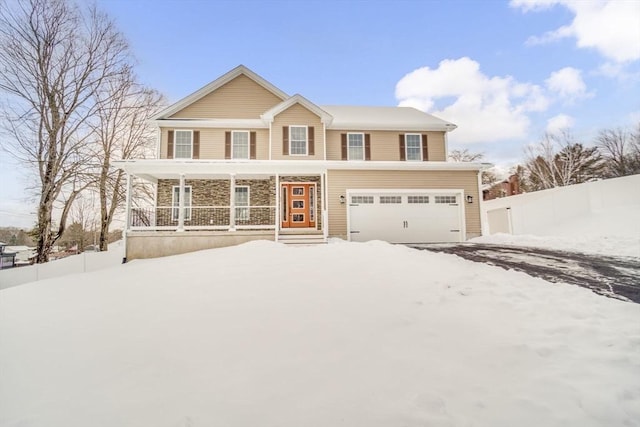 traditional home with covered porch, an attached garage, and fence