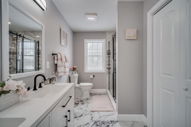 bathroom featuring marble finish floor, a closet, a stall shower, vanity, and baseboards