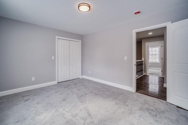 unfurnished bedroom with carpet, baseboards, and a closet