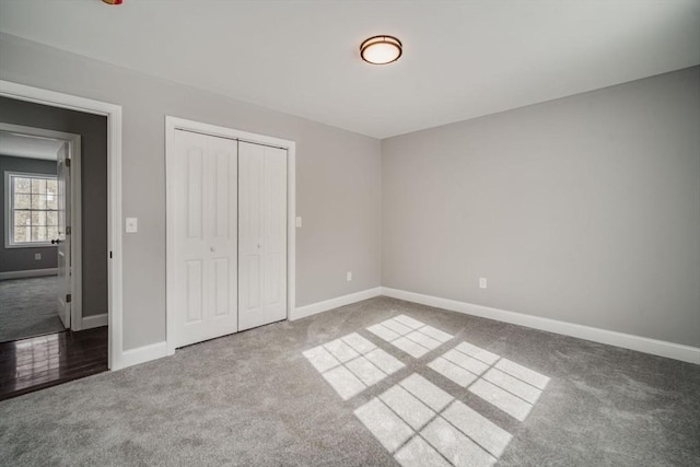 unfurnished bedroom with a closet, carpet flooring, and baseboards