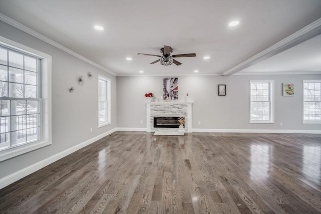 unfurnished living room featuring ornamental molding, wood finished floors, a glass covered fireplace, and baseboards