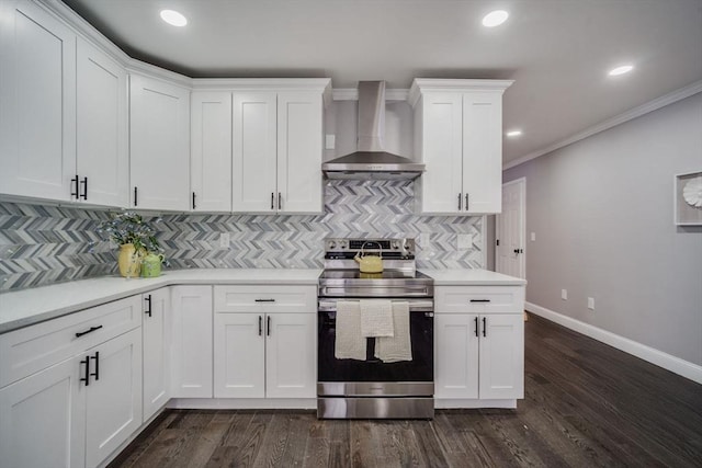 kitchen featuring wall chimney exhaust hood, electric range, light countertops, and white cabinetry