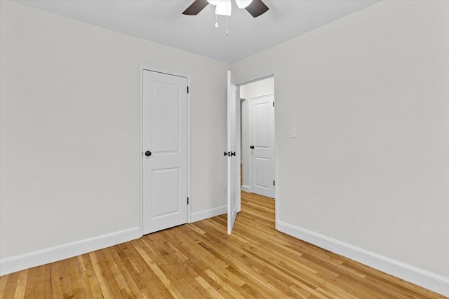 empty room with ceiling fan and light hardwood / wood-style flooring