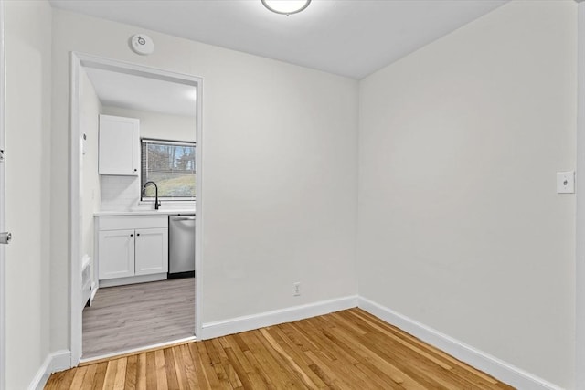 unfurnished room with light hardwood / wood-style floors and sink