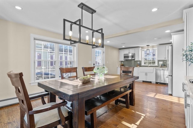 dining space featuring a wealth of natural light, a notable chandelier, and wood-type flooring