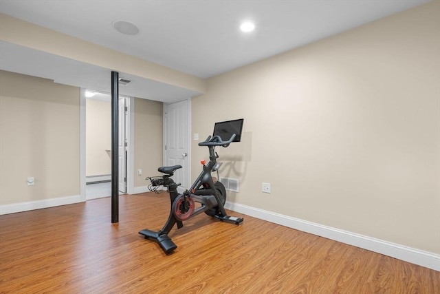 exercise area featuring light hardwood / wood-style flooring and a baseboard radiator