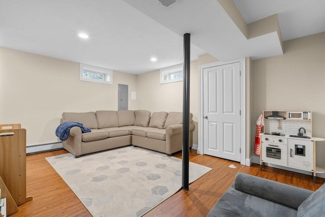 living room with electric panel, hardwood / wood-style floors, and a baseboard radiator