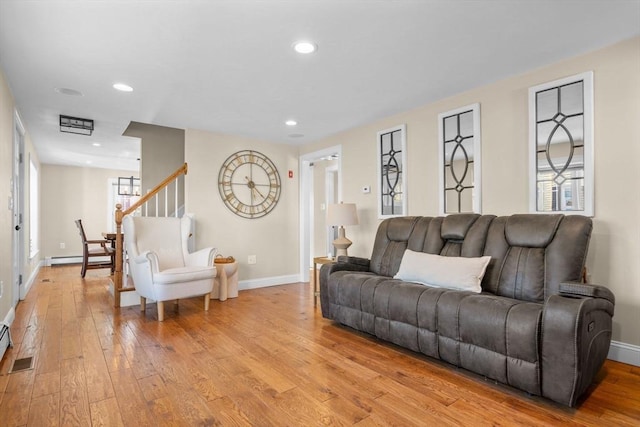 living room with baseboard heating and light hardwood / wood-style floors