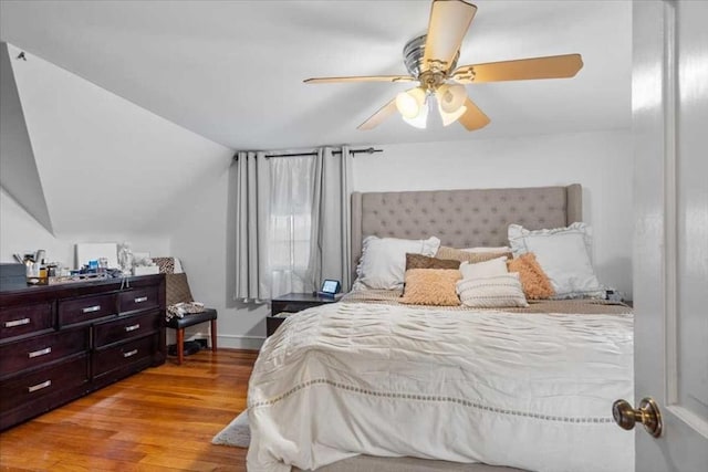 bedroom featuring ceiling fan, light wood-type flooring, and lofted ceiling