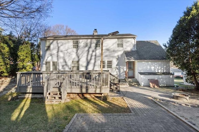 back of property featuring a fire pit, a deck, and a patio