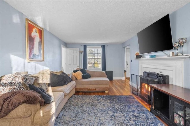 living room with a fireplace, wood-type flooring, and a textured ceiling