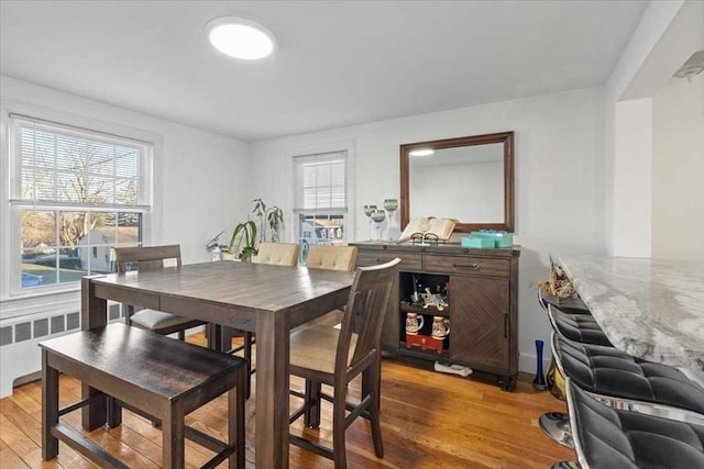 dining room with wood-type flooring and radiator