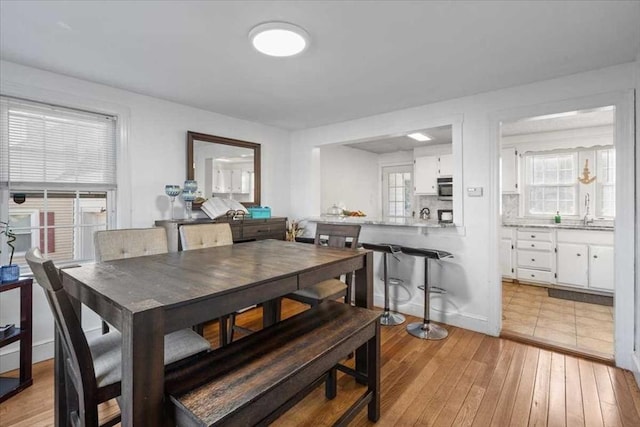 dining area with sink and light hardwood / wood-style flooring