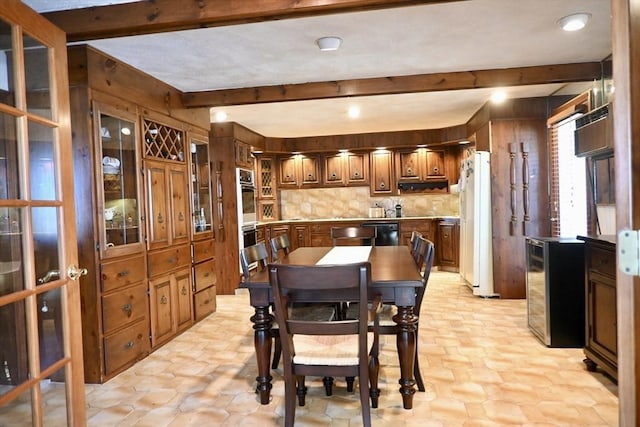 dining room featuring beamed ceiling and beverage cooler