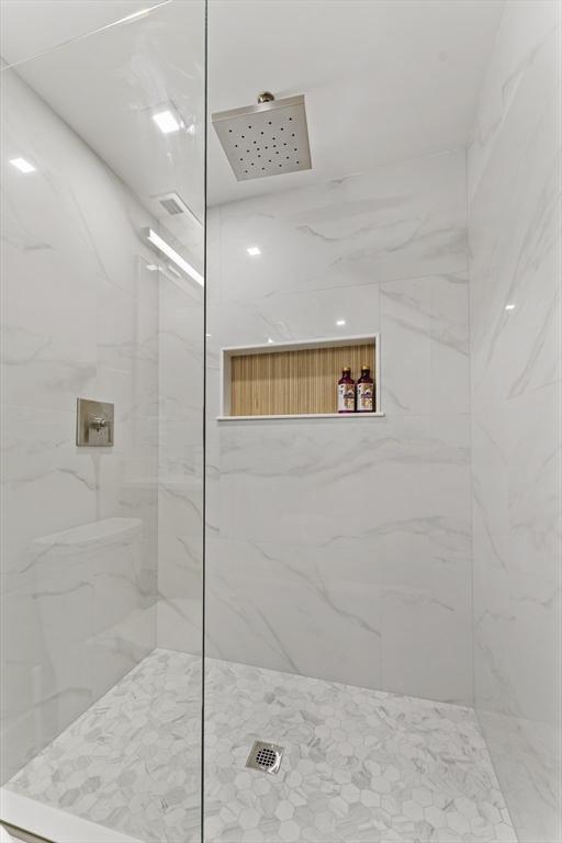 bathroom featuring a marble finish shower