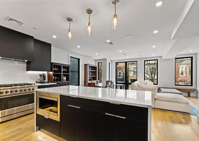 kitchen featuring dark cabinets, appliances with stainless steel finishes, modern cabinets, pendant lighting, and recessed lighting