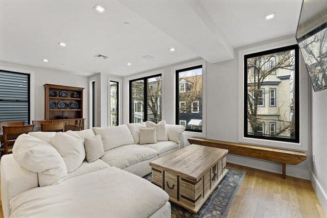 living room with baseboards, wood finished floors, and recessed lighting